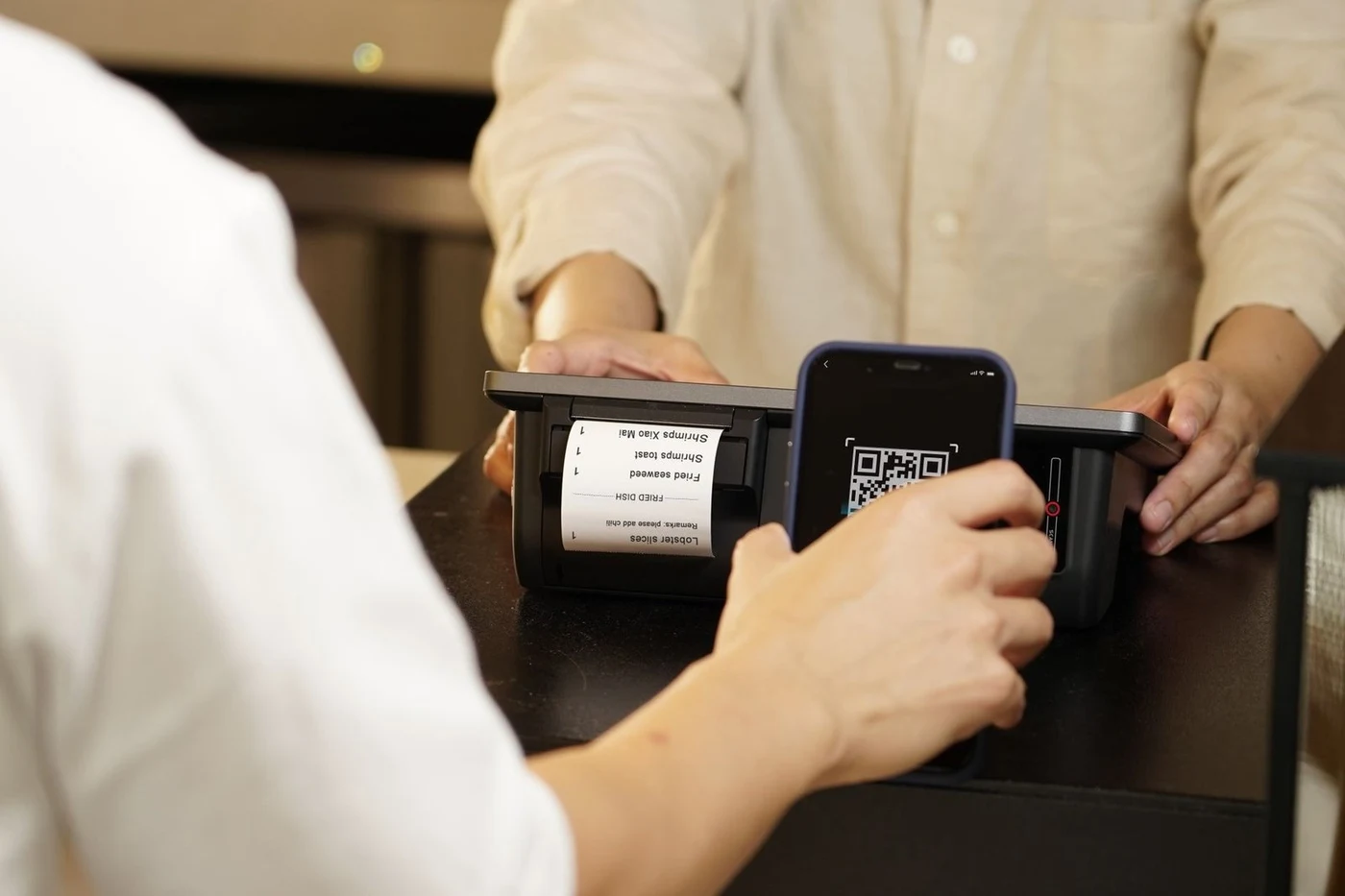 Покупатель платит по QR-коду с телефона на кассе