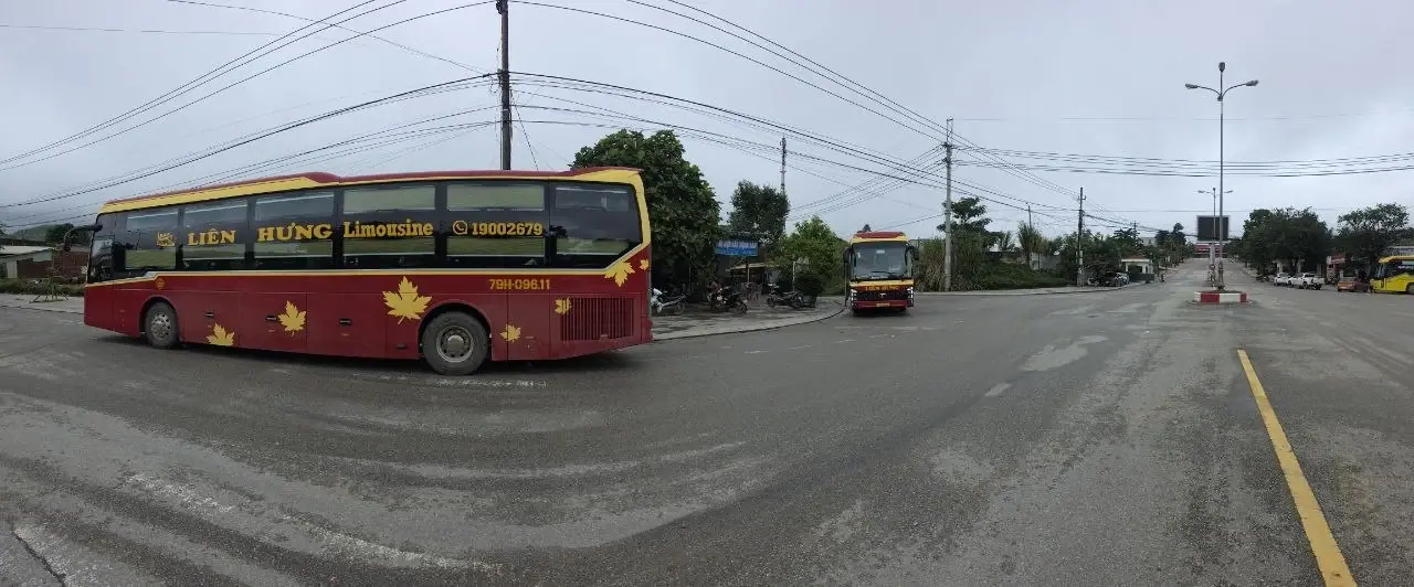 Панорама площадки перед погранпереходом, два автобуса Liên Hưng на перекрёстке