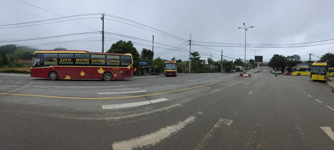 Широкая панорама площадки перед погранпереходом с автобусами на фоне гор
